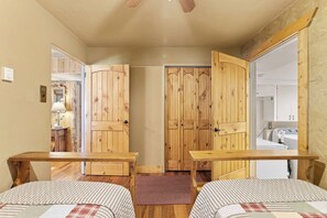 Ein Schlafzimmer mit zwei Betten, einem Holzschrank und einem kleinen Tisch.