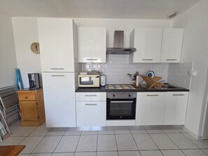 Eine moderne Küche mit weißen Schränken, einer Mikrowelle, einem Toaster und einem Spülbecken.