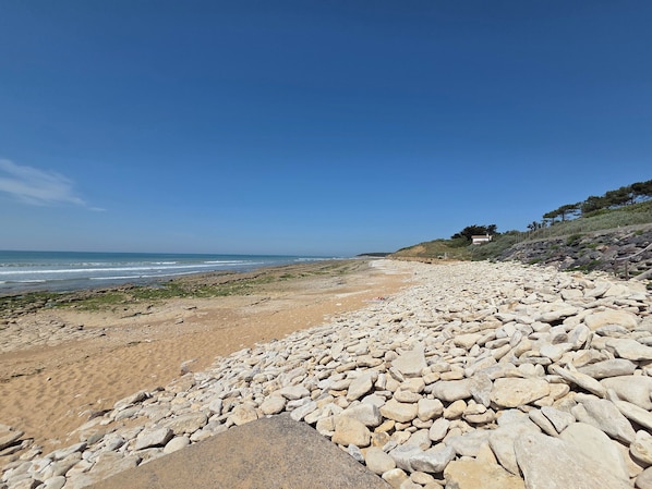 Ein felsiger Strand unter blauem Himmel.
