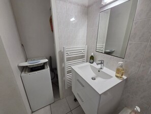 A bathroom with a white sink, a mirror, a towel rack, and a small white cabinet. - Charming cottage with pool - 4 guests (Jard-sur-Mer)