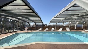 A swimming pool with sun loungers and a covered patio area. - Beach house with AC - 6 guests (Saint-Pair-sur-Mer)