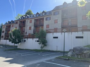 Un hôtel à plusieurs étages doté de balcons, d’un parking et offrant une vue sur un ciel dégagé.