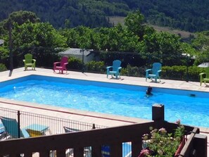 A swimming pool with multiple chairs around it, surrounded by greenery and a fence. - Mobile home, pets allowed - 5 guests (Vesseaux)