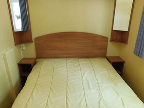A single bed with a wooden headboard, two bedside tables, and a wall-mounted mirror. - Mobile home, pets allowed - 5 guests (Vesseaux)
