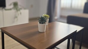 Une table en bois avec un pot de plante placé au centre.