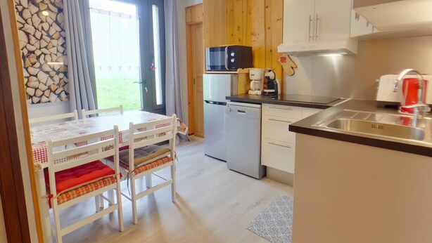 Una cocina moderna con armarios de madera, microondas integrado, cafetera y lavavajillas.