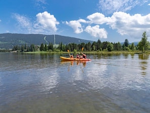 A calm lake with kayaks, surrounded by trees and mountains. - Charming apartment - 4 guests (Prémanon)