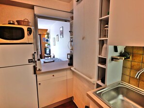 A compact kitchen with a microwave, refrigerator, and a sink. - Pleasant duplex with view - 6 guests (Le Grand-Bornand)
