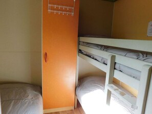 Ein Schlafraum mit Etagenbett, einem Einzelbett und einem Kleiderschrank.