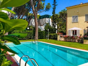 A swimming pool with a clear blue water, surrounded by a well-maintained lawn and trees. - Villa with pool & AC, near the sea - 6 guests (Platja d'Aro)