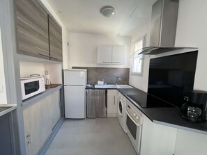 A compact kitchen with a microwave, refrigerator, oven, and sink. - Apartment in city center, small sea view - 4 guests (Valras-Plage)