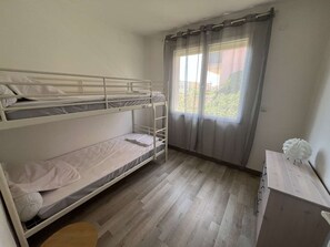 A bunk bed room with a window, a desk, and a chair. - Apartment in city center, small sea view - 4 guests (Valras-Plage)