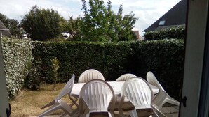 An outdoor patio with a table and four chairs. - Cottage with garden and pool - 4 guests (Dives-sur-Mer)