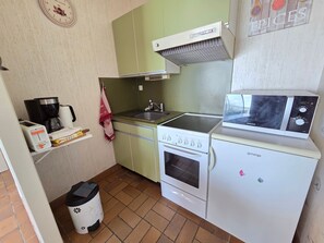 A compact kitchen with a stove, microwave, and a small refrigerator. - Apartment with port view - 4 guests (Jard-sur-Mer)
