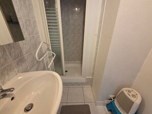 Ein Badezimmer mit Waschbecken, Dusche und Duschbrause.