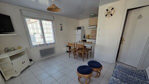 Un espace de vie compact comprenant un coin repas, une kitchenette et un canapé.