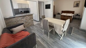 Un espacio habitable compacto con kitchenette, comedor, dormitorio y baño.
