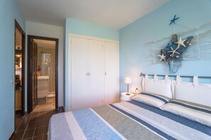 A bedroom with a bed, a nightstand, a lamp, a wardrobe, and a wall decoration. - Apartment in Sa Tuna with views (Begur)
