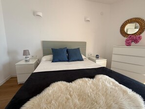 A bedroom with a bed, bedside tables, a dresser, a mirror, and a fluffy rug. - Apartment with sea view - 3 guests (San Antonio de Calonge)