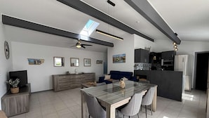 Een moderne woonruimte met een eetgedeelte, keuken en zithoek.