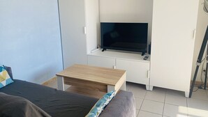 A room with a bed, a desk, a TV, and a wardrobe. - Studio cabin, parking, near beach - 4 guests (Le Grau-du-Roi)