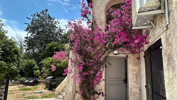 Un edificio con fachada de piedra, una puerta y un pequeño porche.