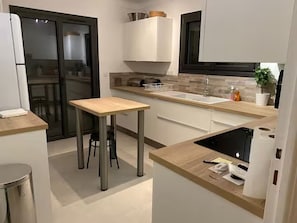 A compact kitchen with a central island, a built-in oven, and a microwave. - Lovely house with sea view - 8 guests (Cavalaire-sur-Mer)