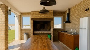 Cozinha moderna com ilha central, lareira embutida e uma janela ampla.