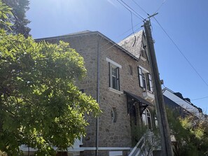 A stone building with a gabled roof and multiple windows, surrounded by trees. - Large typical Bauloise villa - 12 guests (La Baule)