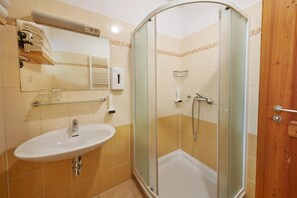 A bathroom with a glass-enclosed shower, a sink, and a mirror. - Garni Hotel Rute (Kranjska Gora)