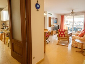 A living room with a dining area, a TV, and a balcony with a view. - Bright apartment in Estepona with balcony and private parking (Estepona)