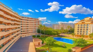 Et hotel med flere etager, swimmingpool, børnelegeplads og en velplejet græsplæne.