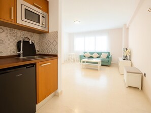 A compact kitchen with a dishwasher, a microwave, and a sink. - Beachfront Studio in Estepona, sleeps 4, with air conditioning (Estepona)