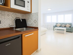 Una cuina moderna amb rentaplats integrat, microones i un rentamans.