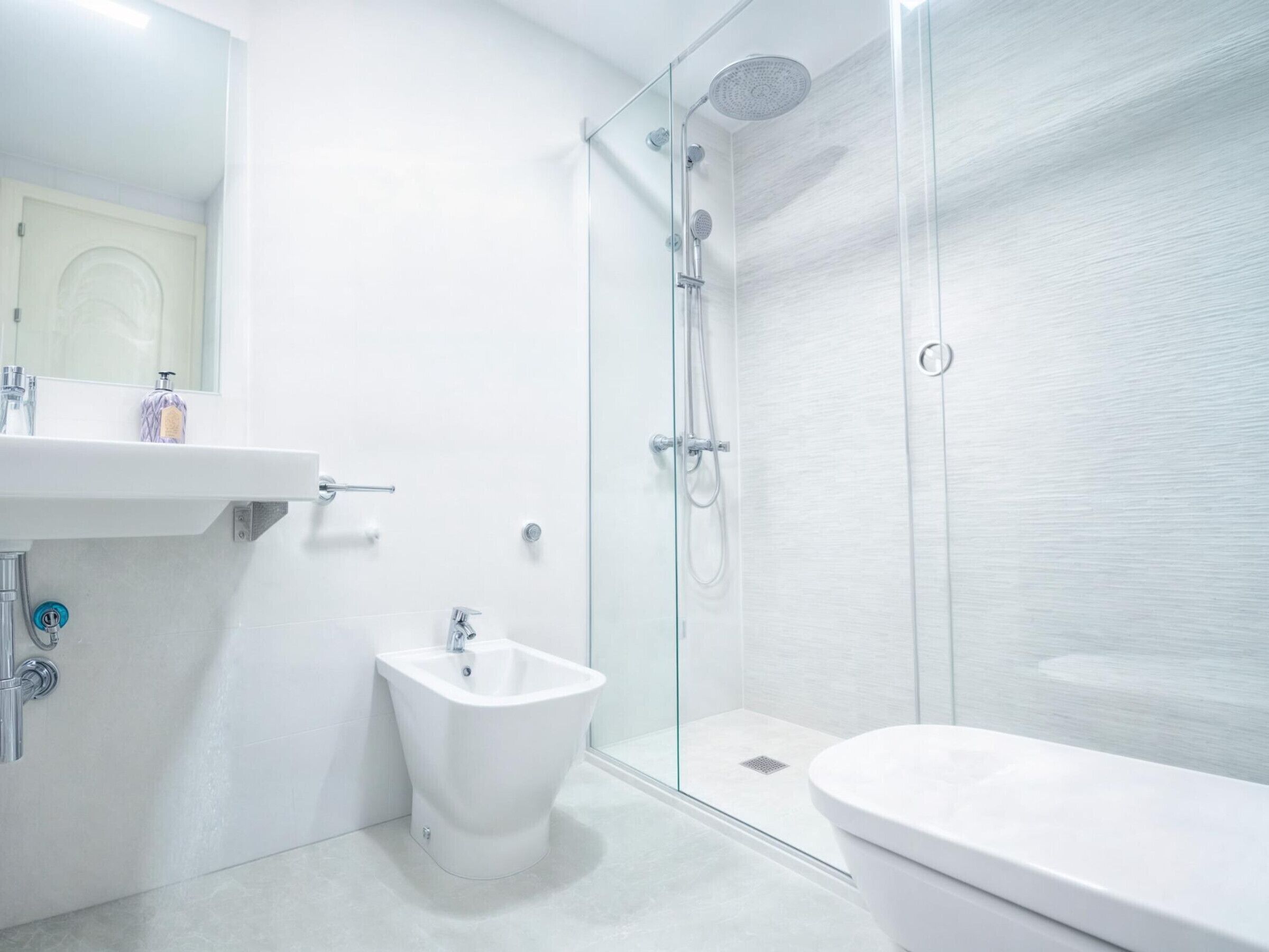 Une salle de bain moderne avec une douche à parois de verre, un bidet et des toilettes.