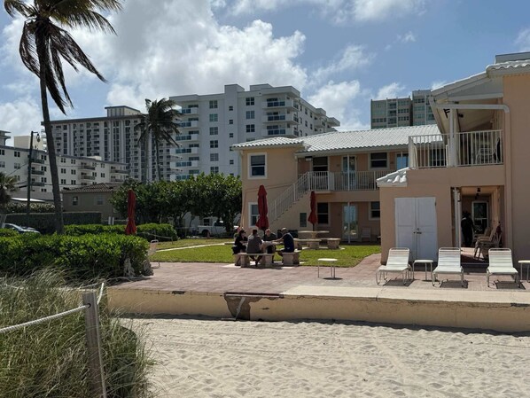 Hotel aan het strand met terras, zwembad en uitzicht op zee.