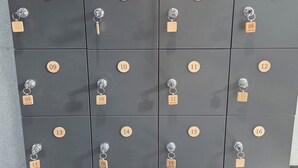 Fila de taquones oscuros de habitaciones de hotel con etiquetas y llaveros numerados.