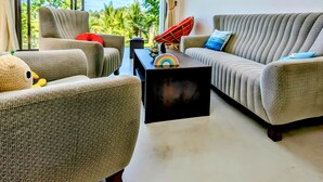 A modern living room with large windows, a sofa set, a coffee table, and a colorful painting. - Tranquil Heaven (Galle)