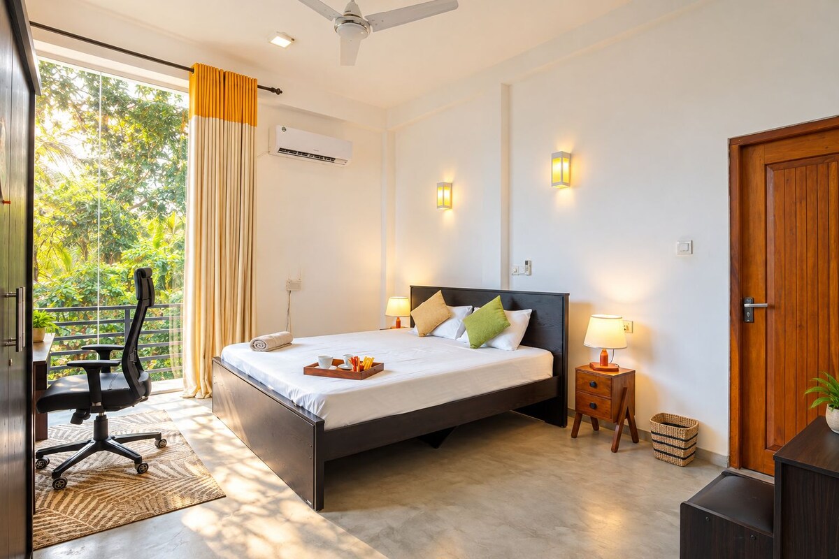 A hotel room with a bed, bedside tables, a desk, and a chair.