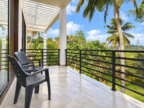 A balcony with a view of a lush green landscape and palm trees. - Tranquil Heaven (Galle)