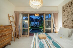 Ein Schlafzimmer mit Bett, einem Holzschrank, einer Leiter, einem großen Fenster mit Blick auf einen Pool und Grünflächen sowie einer dekorativen Wandverkleidung.