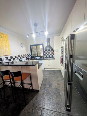 Una cocina moderna con una isla central, electrodomésticos de acero inoxidable y un salpicadero a cuadros.