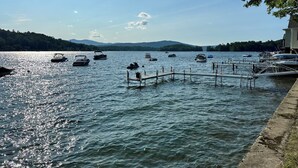 Un lago con barcos amarrados a un muelle, rodeado de colinas.