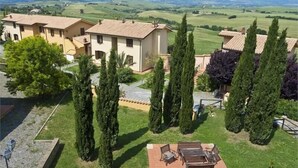 Una vila amb terrassa, ciberpírets alts i vistes a turons ondulats.