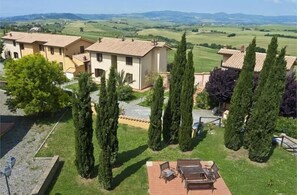 A villa with a patio, tall cypress trees, and a view of rolling hills. - Pomaia - Two Bedroom (Santa Luce)