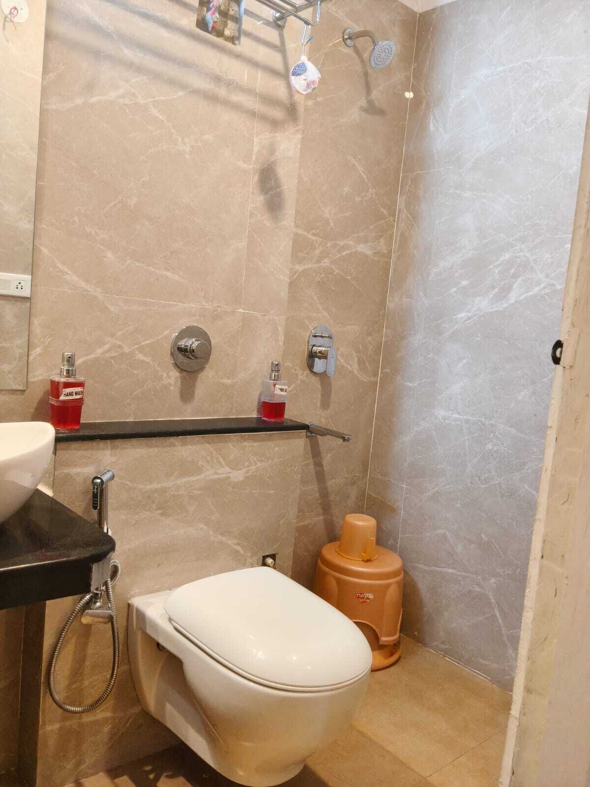 Une salle de bain comprenant des toilettes, un lavabo et un espace douche.