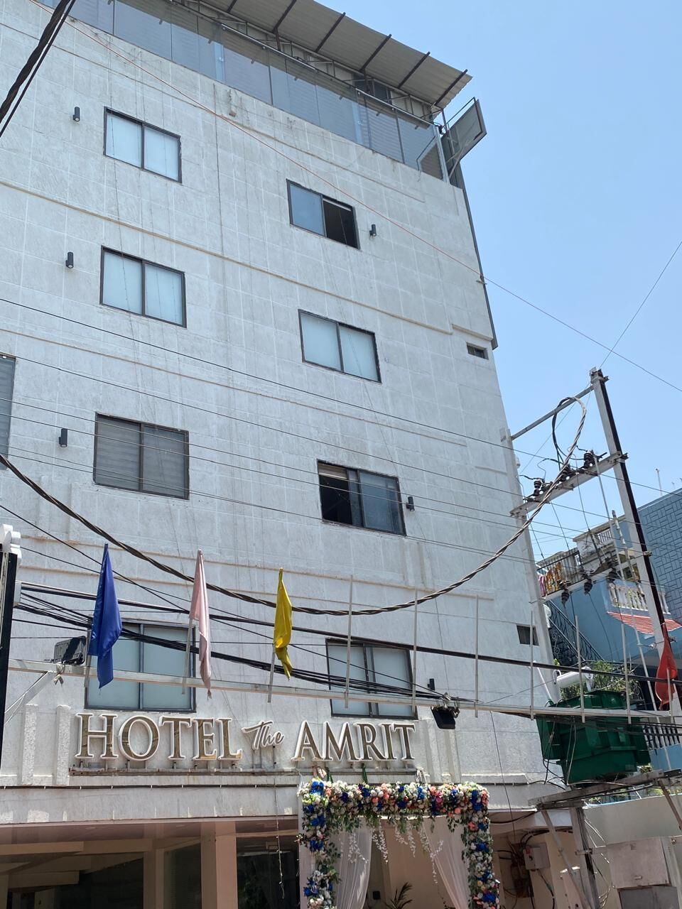 A multi-story hotel with a sign reading 'HOTEL The AMRIT.'