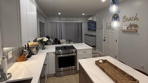 A modern kitchen with white cabinetry, stainless steel appliances, and pendant lighting. - New Luxury 3 bedroom 3.5 baths Condo located in the heart of Salisbury Beach. (Salisbury)
