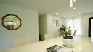 A modern dining area with a marble table, a potted plant, and a book. - World Cup Oasis. 12 min from Beach & Casino. 18 min from World Cup stadium. (Hollywood)