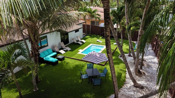 A backyard with a swimming pool, green lawn, and outdoor furniture. - World Cup Oasis. 12 min from Beach & Casino. 18 min from World Cup stadium. (Hollywood)